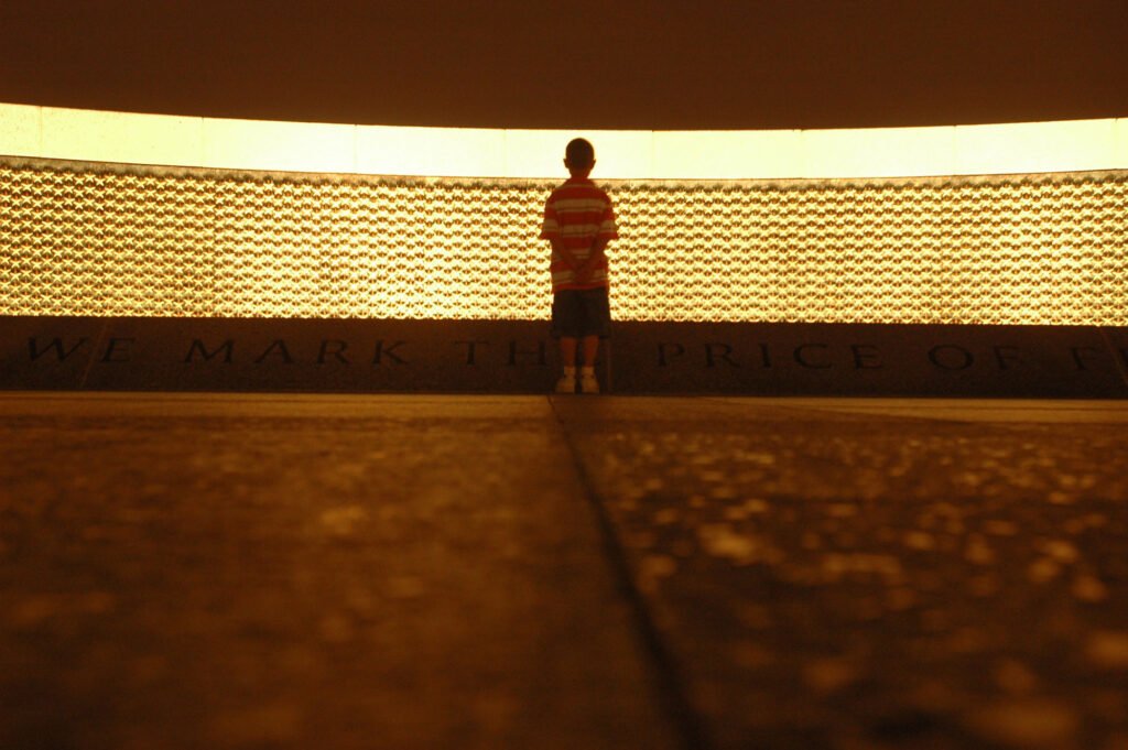 A boy stops and ponders the meaning of the price of freedom stars at the World War II Memorial in Washington D.C. There are 4,800 stars on the wall. Each star represents 100 U.S. servicemembers deaths. Photo by Spc. Ferdinand Thomas, 214th MPAD, Richmond, Virginia/DoD, Released.