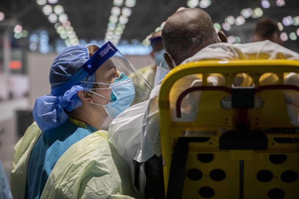 Army Sgt. Marlenny Medina, assigned to the 1st Medical Brigade deployed from Fort Hood, Texas, in support of the Department of Defense COVID-19 response, asks a COVID-19 patient about his medical history, at the Javits New York Medical Station’s patient receiving dock, April 9, 2020. U.S. Northern Command, through U.S. Army North, is providing military support to the Federal Emergency Management Agency to help communities in need. (Spc. Nathan Hammack)