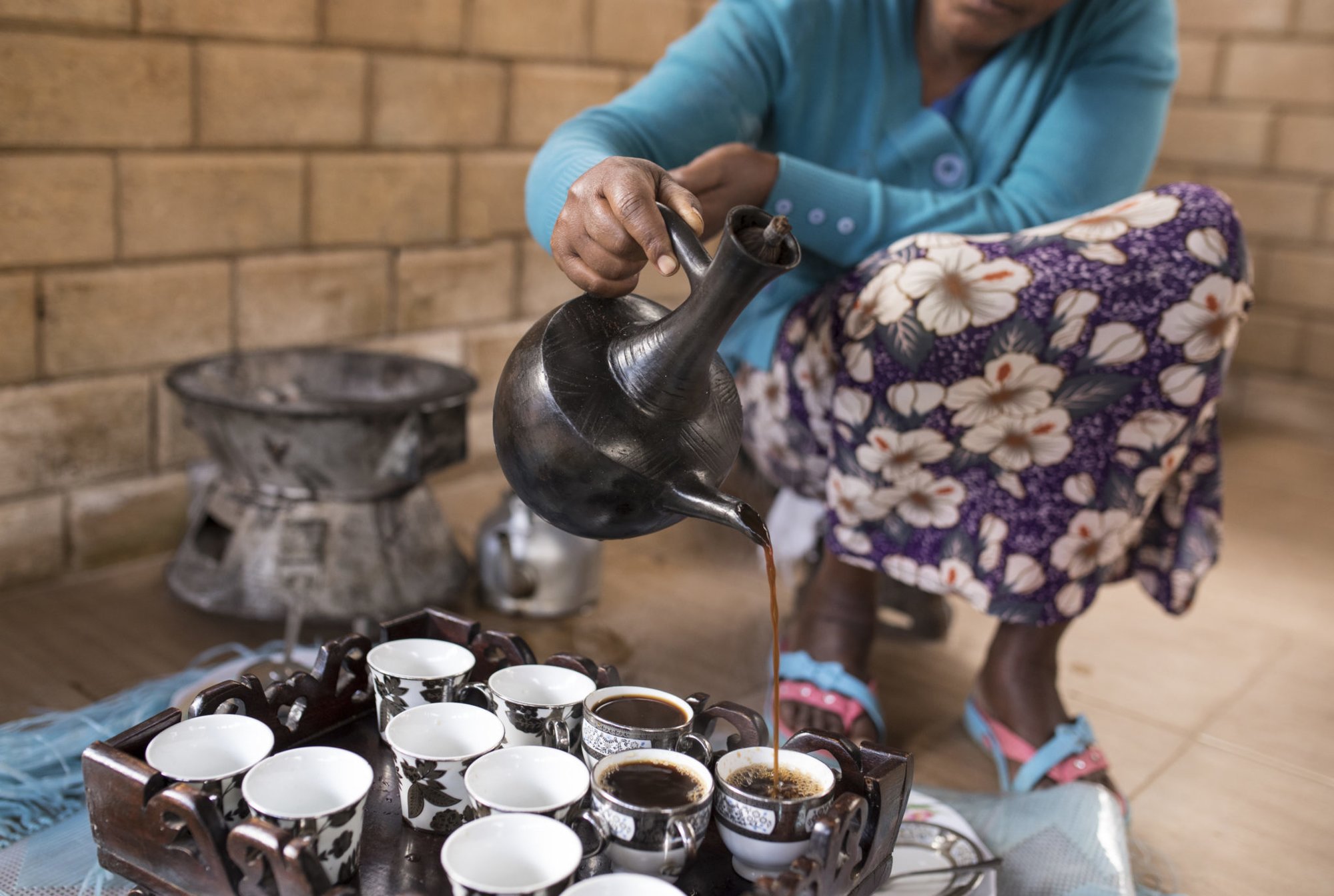 Closeup of Ethiopian womans hands as she pours coffee in Ethiopian coffee ceremony.