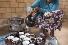 Closeup of Ethiopian womans hands as she pours coffee in Ethiopian coffee ceremony.