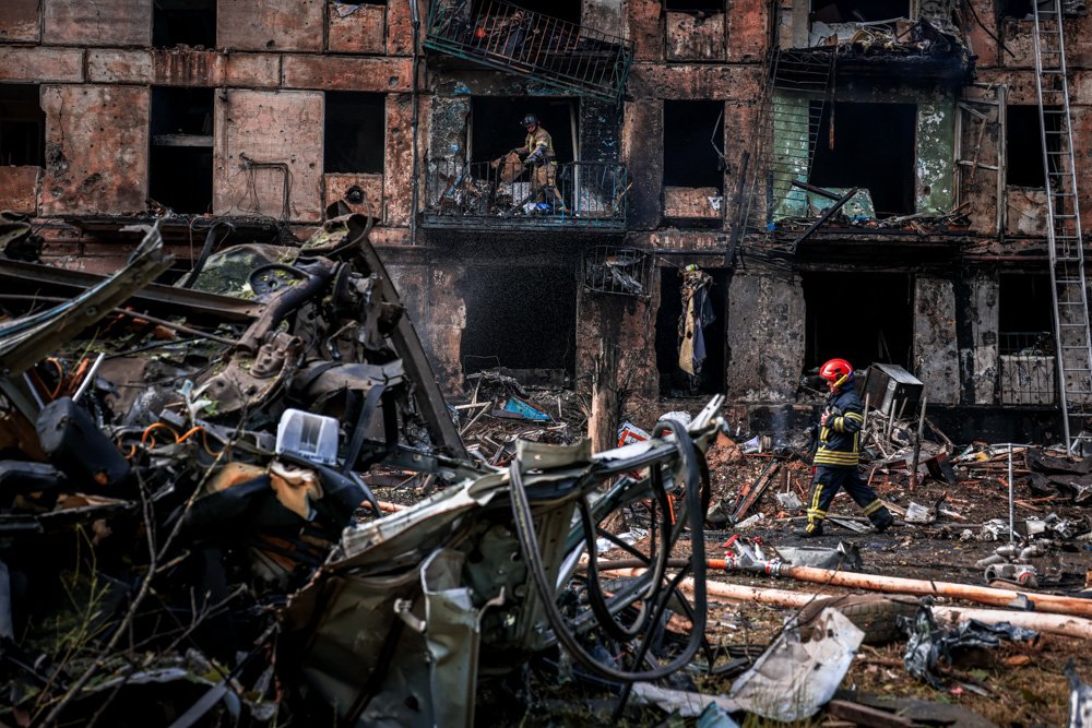Emergency workers inspect a damaged multi-story apartment building caused by the latest rocket Russian attack.