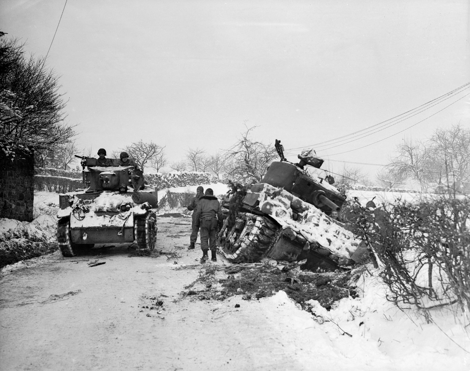 January 1945:  Hard going for US tanks at Amonines, Belgium, on the northern flank of the ‘battle of the bulge’. A tank on the road passes another being dug out of the snow.  (Photo by Fred Ramage/Keystone/Getty Images)