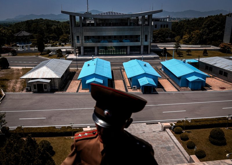 A South Korean building complex is seen in the background as North Korean soldiers guard the truce village at the Demilitarized Zone (DMZ).