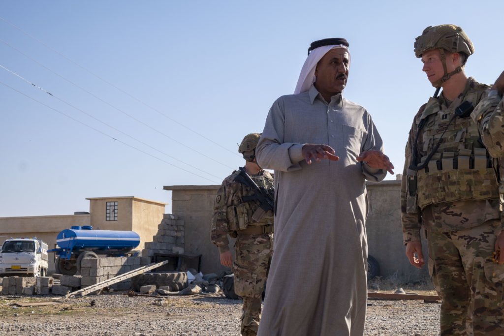 Captain Colin Grant, an infantry company commander at Q-West, chats with Sheikh Hussein, an important tribal leader, during a visit to a village near the base. Photo by Kimberly Westenhiser/Coffee or Die.