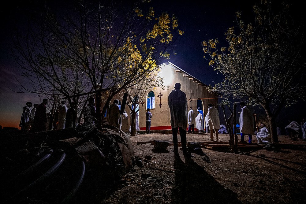 Tigrayan refugee Abraha Kinfe Gebremariam, 40, stands in a doorway of his family's shelter.