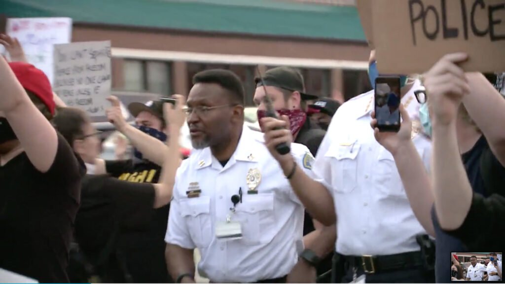 Screen grab from video of Ferguson, Missouri, Police Chief Jason Armstrong marching with protesters.