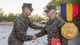 Sgt Maj. Christopher J. Adams, senior enlisted advisor, 4th Marine Division, awards Sgt. Joseph Howard, an infantry mortarman with Weapons Company, 2nd Battalion, 25th Marine Regiment, 4th Marine Division, with the Navy and Marine Corps Medal during a ceremony at McGuire Air Force Base, New Jersey, Dec. 9, 2022. US Marine Corps photo by Lance Cpl. Leslie Alcaraz.
