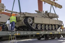 Civilian employees (right) use hand signals to lower the M1A1 “Abrams” tank onto the rail cars aboard Marine Corps Logistics Base Barstow, California, July 7. U.S. Marine Corps photo by Sgt. Jack Adamyk