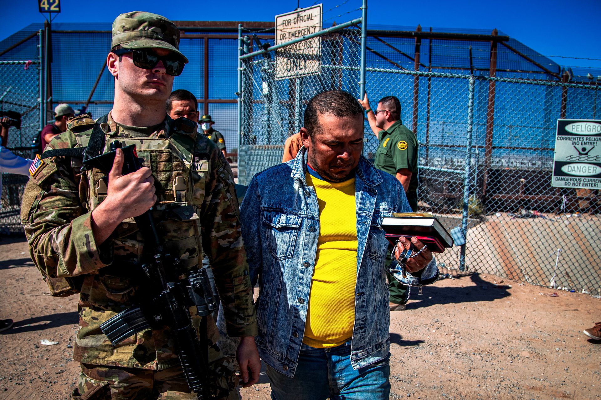 Migrants are escorted by a U.S. Army soldier after entering into El Paso, Texas from Ciudad Juarez, Mexico, to be processed by immigration authorities, May 10, 2023. The Pentagon is pulling 1,100 active duty troops from the U.S.-Mexico border it deployed earlier this year as the government prepares for the end of asylum restrictions linked to the pandemic. AP file photo by Andres Leighton.