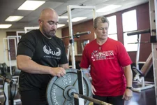 U.S. Marine Corps veteran Charles Dane adds weight to the bar during a 2018 Defense Department Warrior Games powerlifting practice at Cheyenne Mountain High School in Colorado Springs, Colorado. Dane was medically retired from the military after a 19-year career. Photo by Cpl. Juan Madrigal, courtesy of the U.S. Marine Corps.