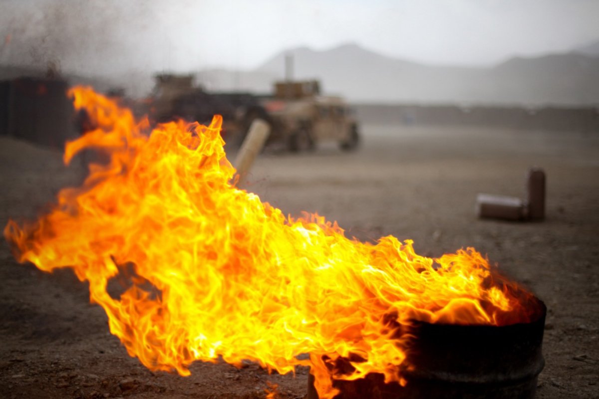 The flames of a burn pit pick up with the winds as a storm approaches Combat Outpost Tangi in the Tangi Valley, Afghanistan, on Aug. 31, 2009. US Army photo by Sgt. Teddy Wade.