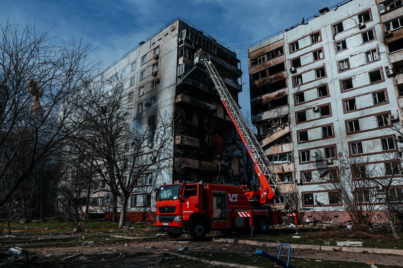 A firefighter puts out a fire after a Russian missile hit a residential multi-story building in southeastern city of Zaporizhzhia, Ukraine, Wednesday, March 22, 2023. (AP Photo/Kateryna Klochko)