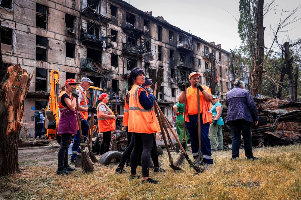 Municipal workers look at the scene of the latest Russian rocket attack that damaged a multi-story apartment building.