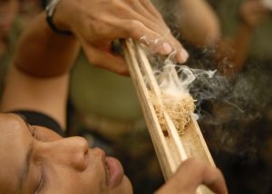 A Royal Thai Reconnaissance Marine demonstrates how to make fire using bamboo.