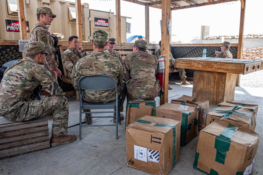 Members of 1-24 sit in the "Smoke Pit" at their camp in Erbil the morning after they handed their camp in Mosul over to Iraqi forces. Their brigades' deployment had been slated to end in June, but many have had their deployments extended as late as August as the global pandemic upends deployment schedules. Photo by Kevin Knodell/Coffee or Die.