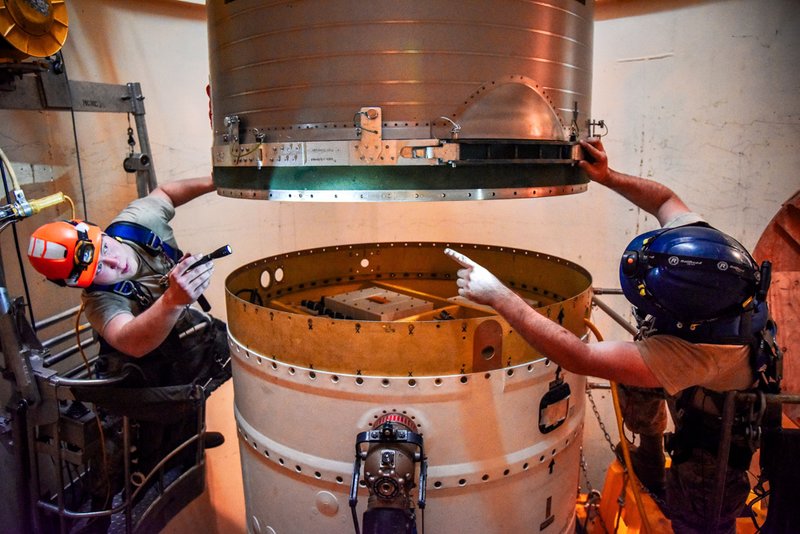 Airman 1st Class Jackson Ligon, left, and Senior Airman Jonathan Marinaccio, 341st Missile Maintenance Squadron technicians connect a re-entry system to a spacer on an intercontinental ballistic missile.