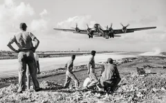 US soldiers at the Saipan air base in the Mariana Islands watch a B-29 Superfortress take off for an air raid on the Japanese mainland in December 1944. AP photo.