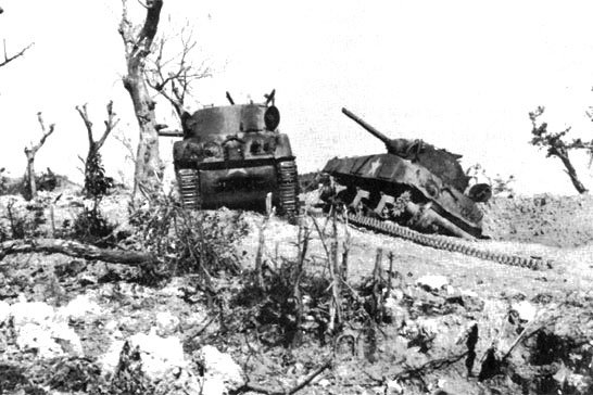 Two U.S. M-4 Sherman tanks are disabled by Japanese artillery during the battle of Bloody Ridge, April 20, 1945. Photo courtesy of the National Archives.