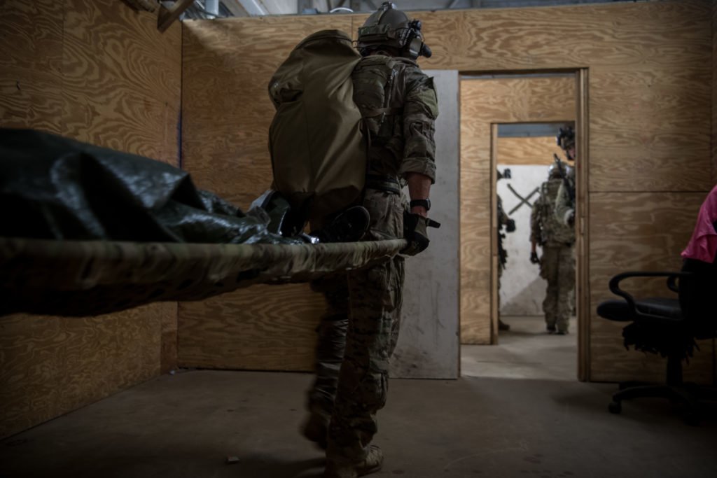 An Air Force Special Tactics operator carries a patient on a stretcher to evacuate during an operability training scenario at Eglin Range, Florida, April 22, 2020. Photo by Staff Sgt. Rose Gudex/U.S. Air Force.