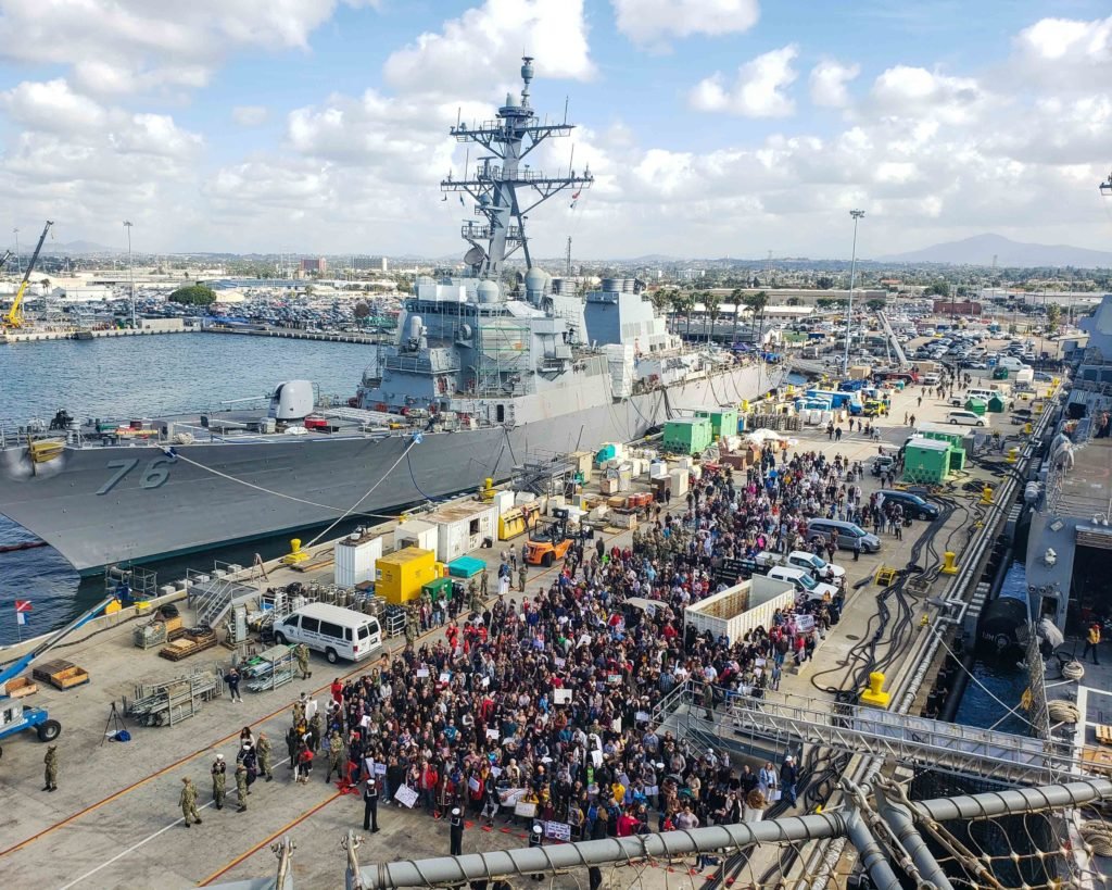 Friends and family members gather near the amphibious assault ship USS Boxer (LHD 4) as the ship moors at Naval Base San Diego on Nov. 27, 2019. Photo by Mass Communication Specialist 2nd Class Justin Daniel Rankin, courtesy of the U.S. Navy.