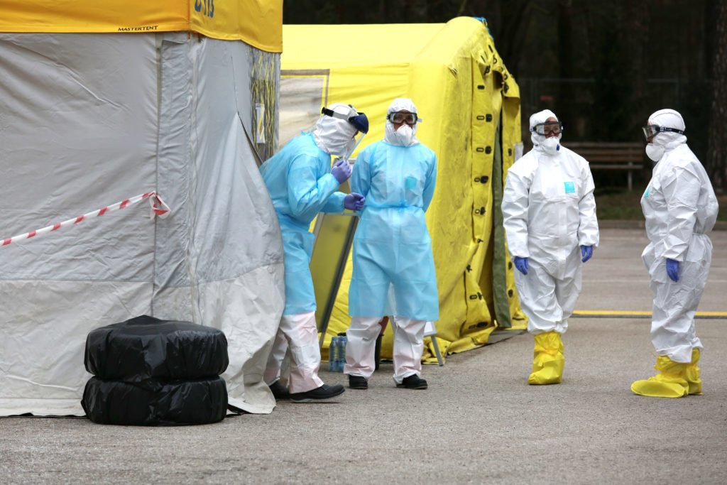 Health care workers wear protective suits as they wait for patients to be tested for coronavirus disease (COVID-19) in Riga, Latvia March 16, 2020. Adobe Stock photo.