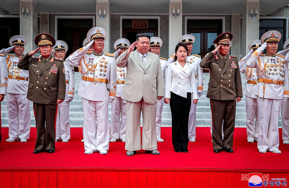 North Korean leader Kim Jong Un, center, with his daughter, center right, reportedly named Ju Ae, review the honor guard during their visit to the navy headquarter in North Korea