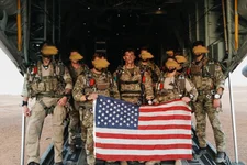 Sgt. Maj. Payne and his teammates prior to a military free fall jump. They hold the American flag to signify duty and devotion to country. Photo courtesy of the US Army.