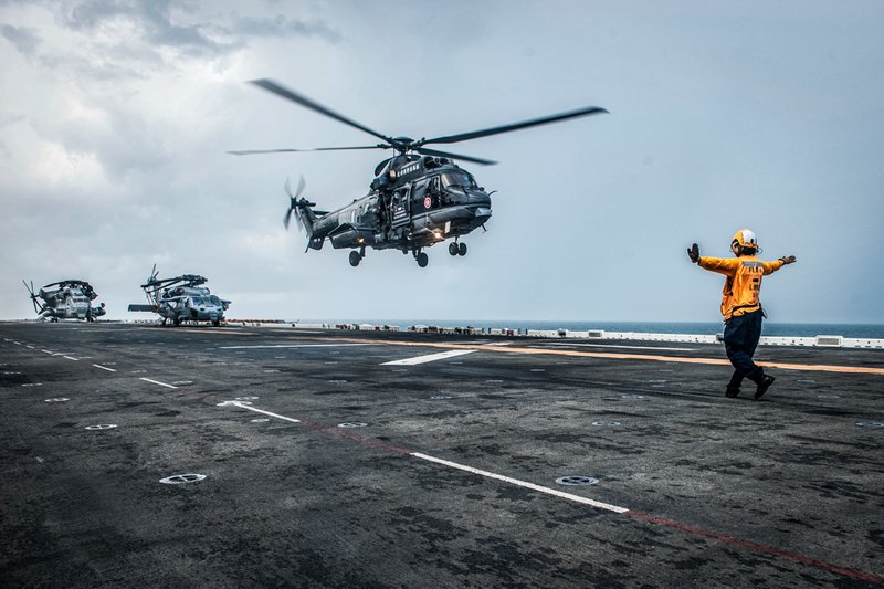 Aviation Boatswain’s Mate (Handling) 2nd Class Nikita Boles directs an AS332 L2 “Super Puma” helicopter.