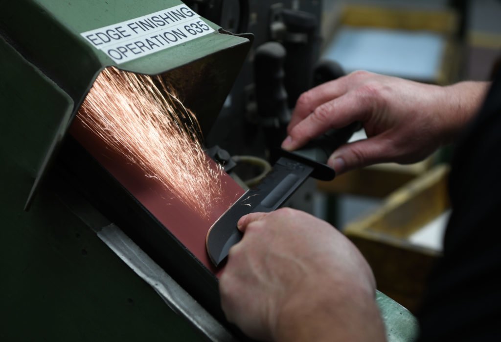 A KA-BAR employee grinds the blade of a knife at a factory in Olean, New York, Nov. 19, 2019. KA-BAR has been issuing the USMC Fighting/Utility KA-BAR knives to the Marine Corps since Dec. 9, 1942. U.S. Marine Corps photo by Lance Cpl. Mellizza P. Bonjoc.