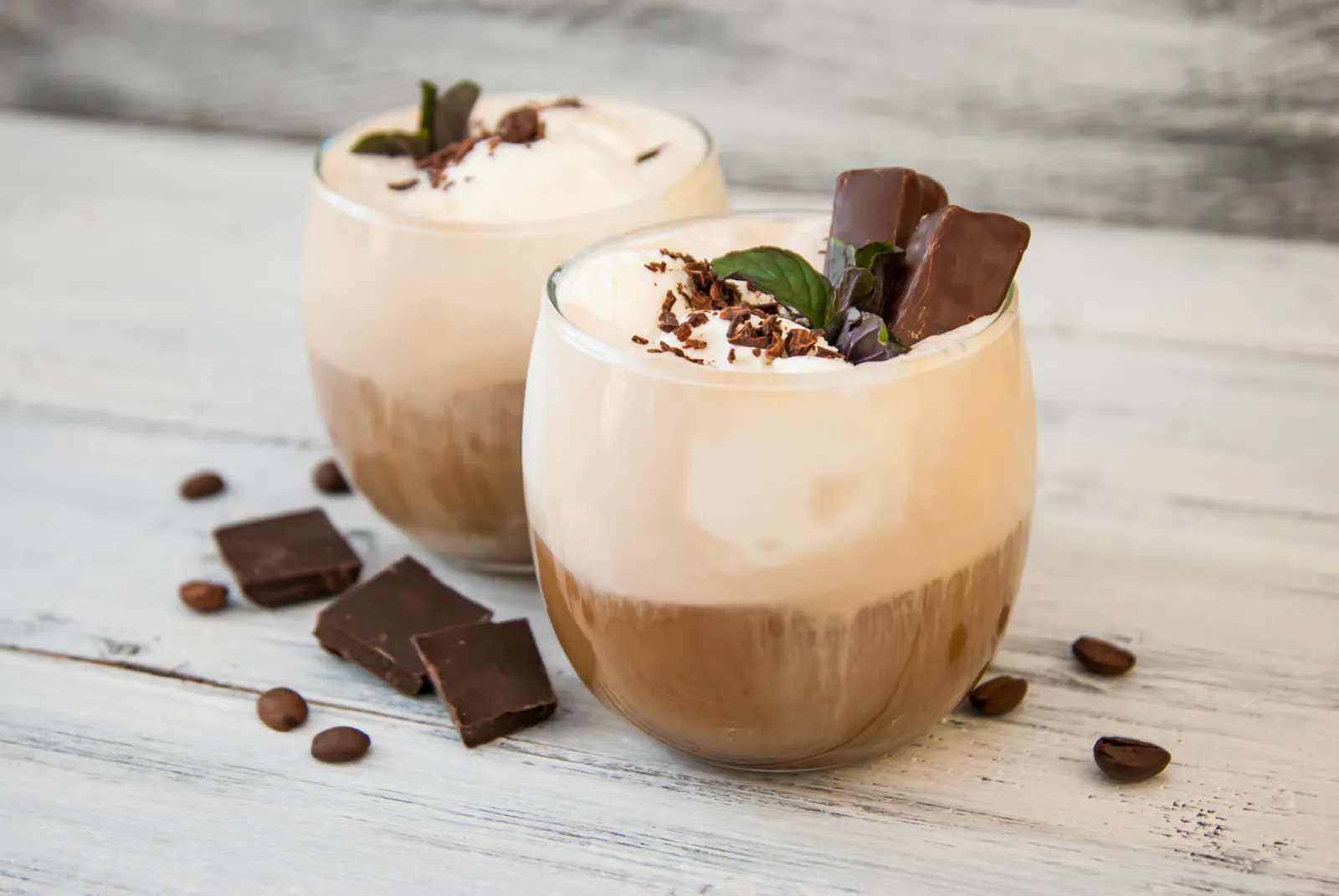 Iced Mocha Coffee with Whip Cream, Summer Drinking times. Coffee Beans. rustic textured Wooden Background. Adobe Stock image.
