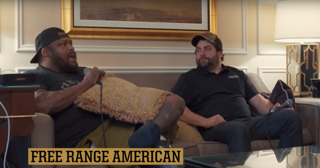 Omar "Crispy" Avila and Jarred Taylor record an episode of Free Range American in Las Vegas during SHOT Show. Screen grab taken from "GUNPOWDER, RACE CARS & COFFEE - CAF Life: Vegas & 2020" on the Black Rifle Coffee Company YouTube page.