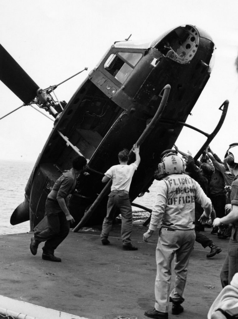 A South Vietnamese helicopter is pushed over the side of the USS Okinawa during Operation Frequent Wind, April 1975. The helicopter, which carried two Vietnamese officers, a woman, and two children, had to be disposed of to make room for the extensive Marine Corps helicopter operation helping to evacuate the city of Saigon. Photo courtesy of the U.S. Marine Corps.