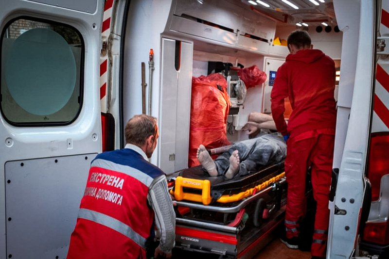 Paramedics move an injured man into an ambulance near the restaurant RIA Pizza.
