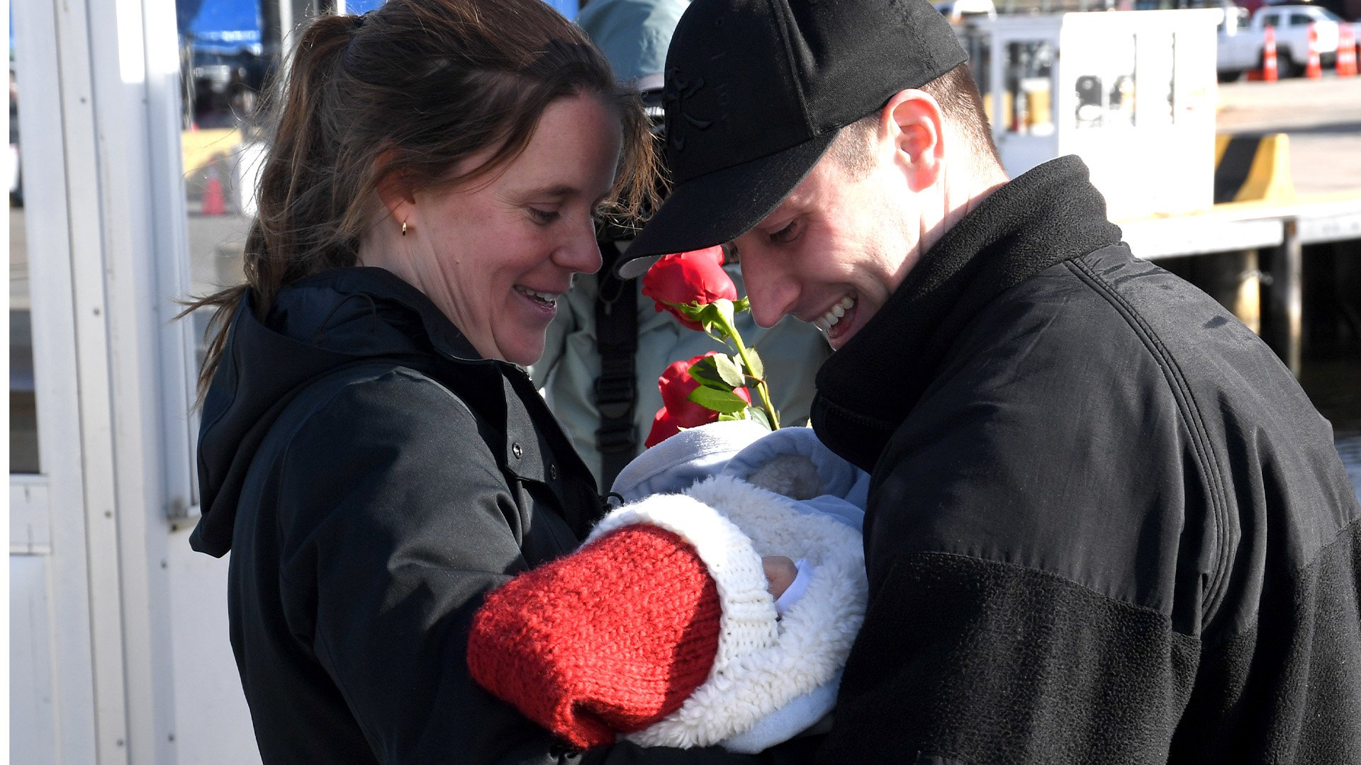 US Navy Lt. Tom Krysil, navigator of the fast-attack submarine California, is greeted by his wife, Molly, and new baby, Christopher,at Naval Submarine Base New London in Groton, Connecticut, on Dec. 8, 2022. California returned to the boat's Groton homeport after a four-month deployment. US Navy photo by Chief Petty Officer Joshua Karsten.