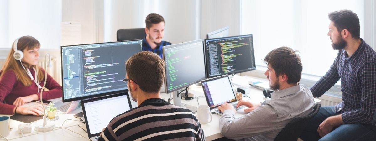 a dedicated software development team working in an open space office and coding