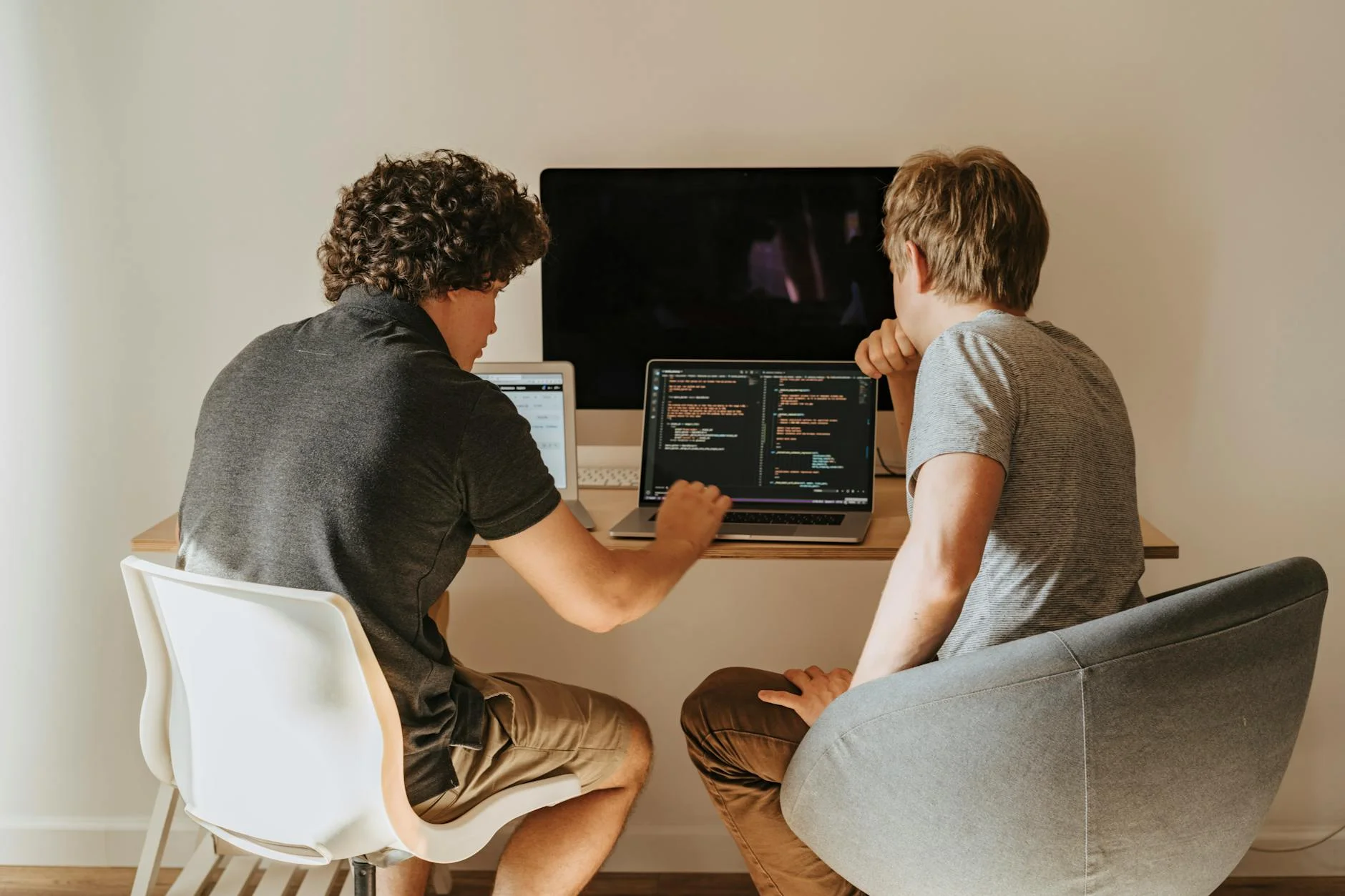 Two software developers collaborating on code, representing teamwork in organizing a GraphQL project