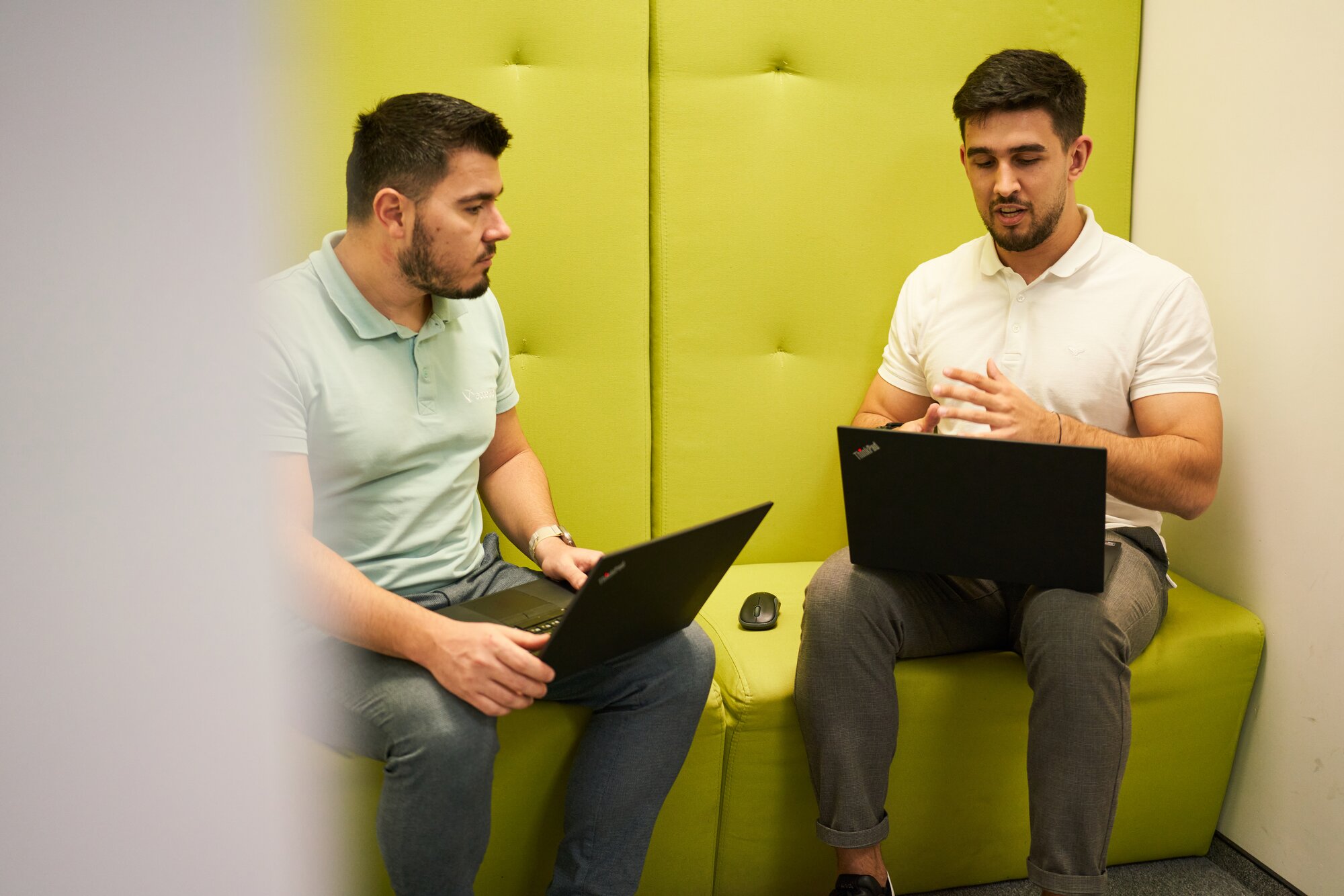 Two colleagues discussing project details in a quiet office space.
