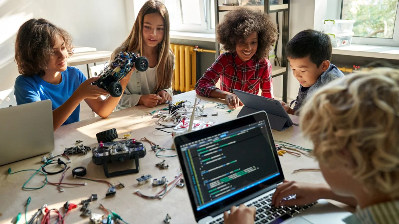 kids are coding, studying on computers and doing robotics