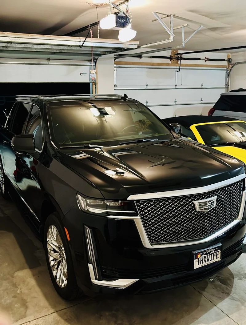 Black Cadillac SUV with a freshly polished finish in a garage