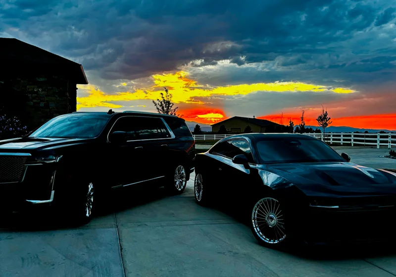 Detailed black coupe and luxury SUV against a golden Colorado sunset