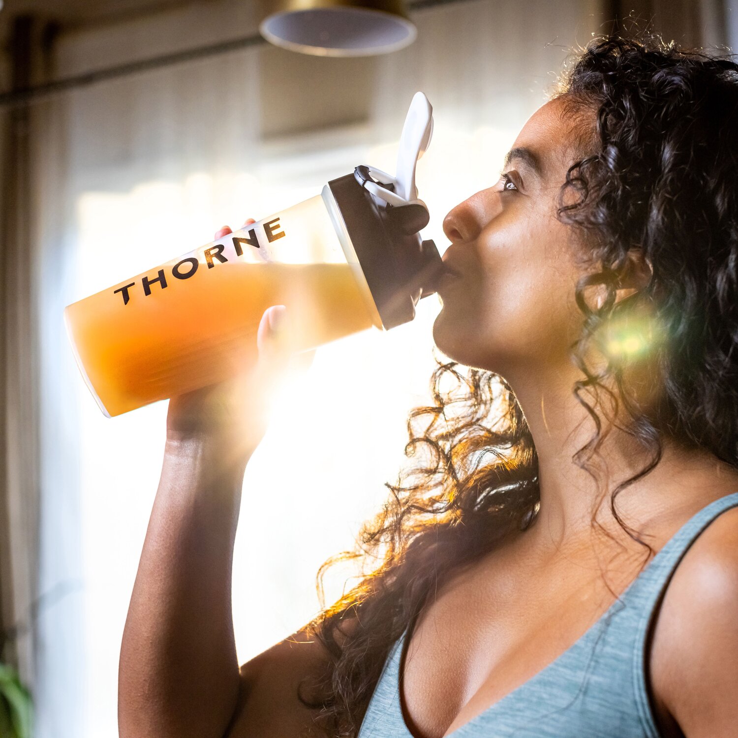 woman drinking from thorne shaker bottle