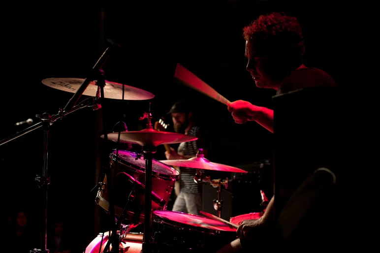 <!--ybor4year-->

Surfer Blood drummer, Tyler Schwarz, doing what he does on his kit, while Kevin Williams thumbs his bass in the background.









