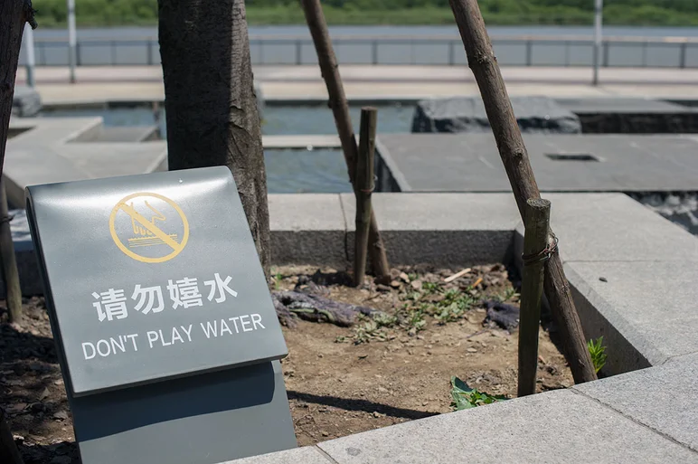 <!-- damnamchina2013 -->

You really want to listen to this sign. This water is beyond sketchy. Your hand might rot away if you go digging for lucky coins.