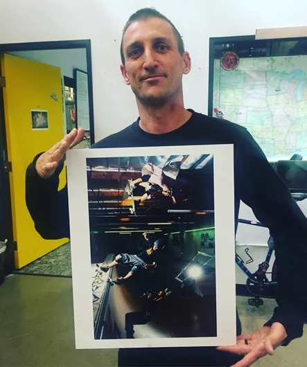 <!--zatcali-->
This is Remy Stratton. He was a 90s vert pro and also the guy who built the Volcom skate program from nothing. Here he is holding a photo of Rune and Matt Dove, if you look closely you’ll see Remy in the photo too, hanging from a trapeze mount like a Flying Wallenda while filming Chichigof. 