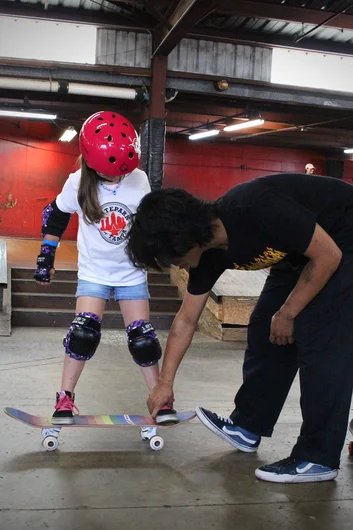 <!--vansgirlsclinic-->
They say those who can’t do, teach. But that’s really not the case with Sam. Here he shows a young lady the proper stance when on the board.
