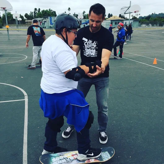 <!--vansgivesback19-->
Ryan Vanderweel giving some hands-on help to a new friend. Ryan is part of the Boards for Bros California Ambassador team. Check out and support his restaurant Grinderz in Huntington Beach right beside the Vans Off the Wall Skatepark. It serves as Boards for Bros California HQ!
