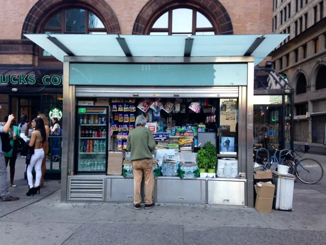 <!--NYCRT-->

An older gentleman tends to his newspaper stand.
