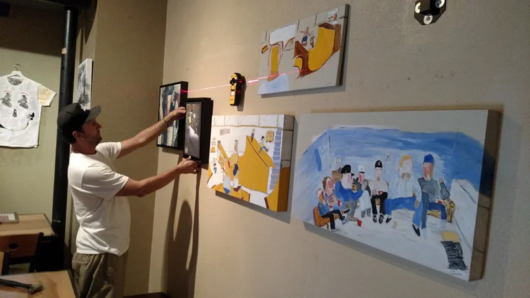 <!--bokmaartshow-->

Brian Schaefer helps adjust the art.