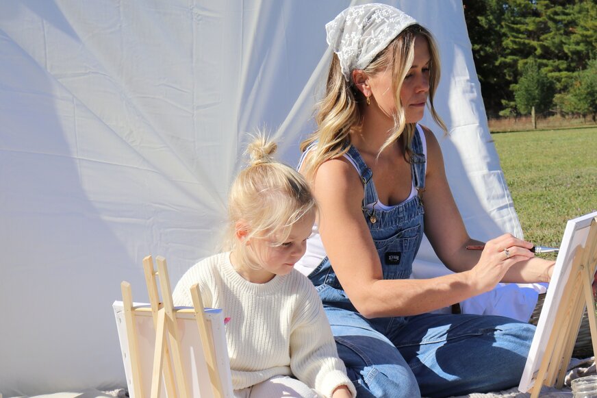 Mom and daughter painting outside. 