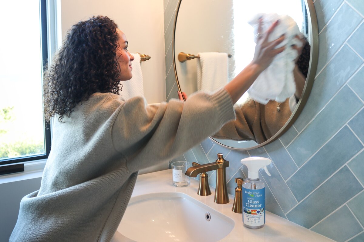 Cleaning bathroom mirror with towel